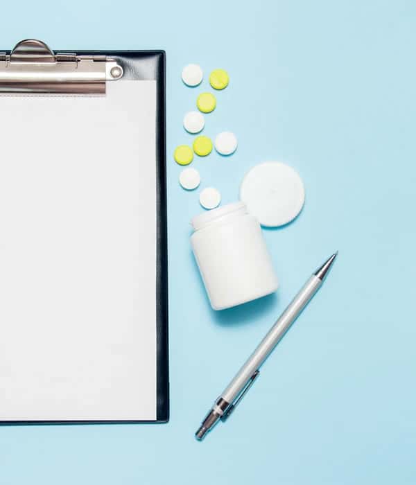 twilight prescription drug clipboard pills pen blue background eow