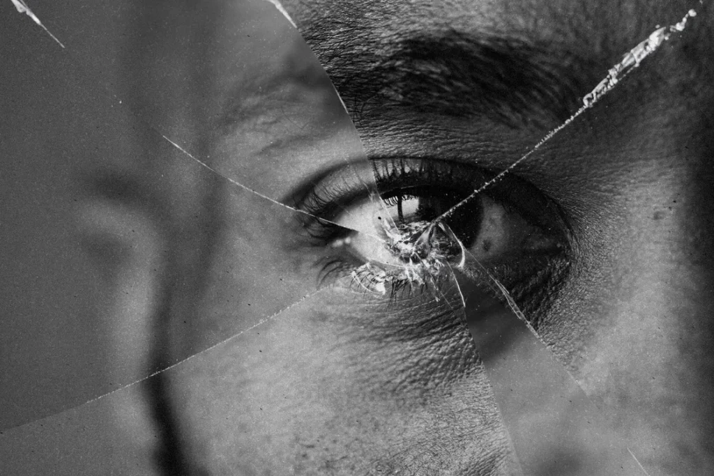 persona viendo una ventana rota