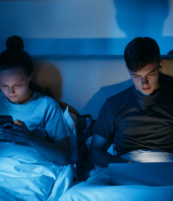 twilight internet addiction couple sitting bed looking tablet