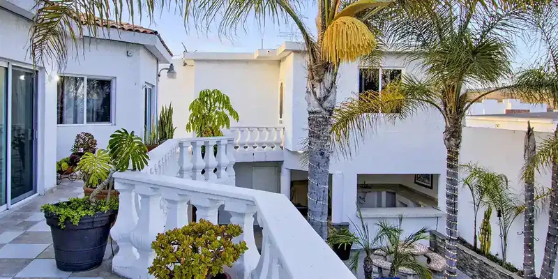 twilight-balcony-palm-trees-white-fence-blog
