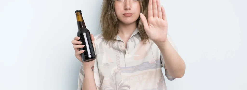Mujer diciendo que no a una botella de alcohol.
